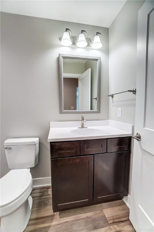 bathroom with vanity, wood-type flooring, and toilet