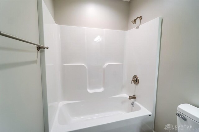 bathroom with tub / shower combination and toilet