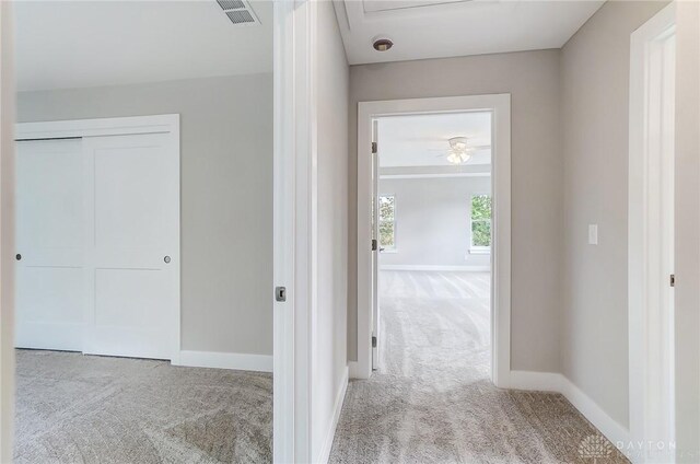 hall with light colored carpet