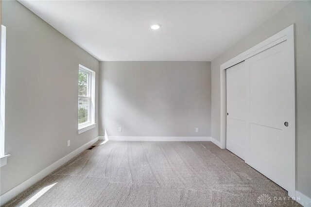 unfurnished bedroom featuring carpet flooring and a closet