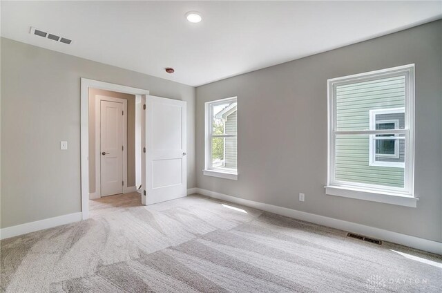 unfurnished room featuring light carpet