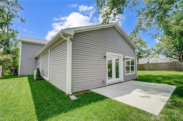 rear view of house featuring french doors, a patio area, and a lawn