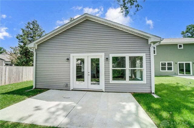 rear view of property featuring a yard, a patio area, and french doors