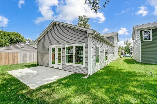 back of house featuring a patio area, french doors, and a lawn