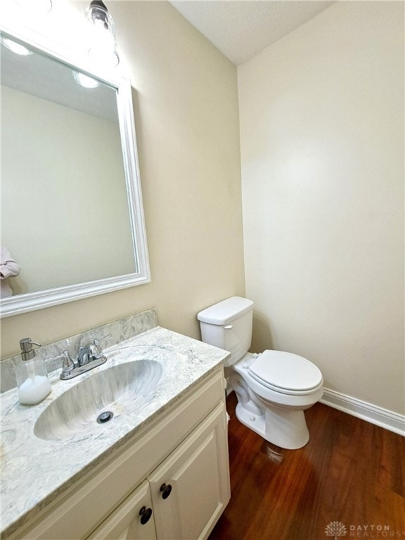 bathroom featuring vanity, hardwood / wood-style floors, and toilet