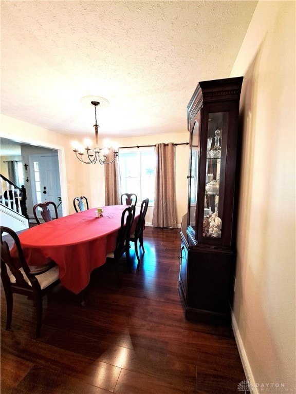 dining room featuring a chandelier, a textured ceiling, and dark hardwood / wood-style flooring