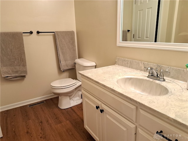 bathroom featuring wood-type flooring, vanity, and toilet