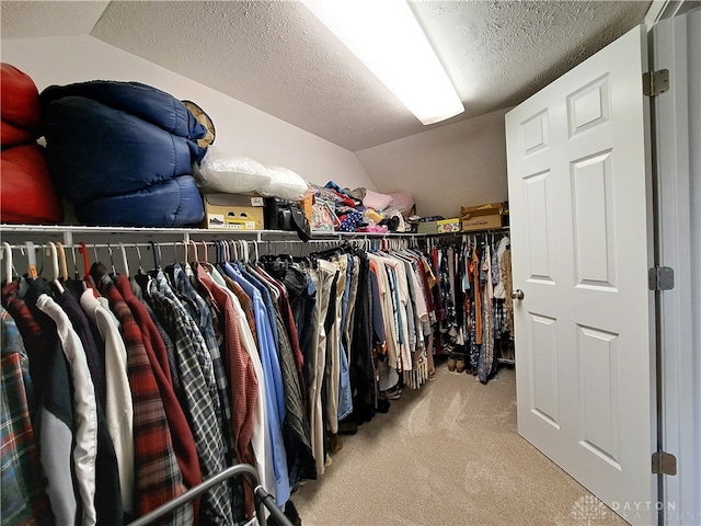 spacious closet featuring lofted ceiling and light carpet