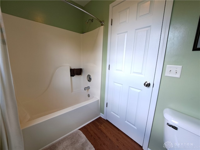 bathroom featuring hardwood / wood-style flooring, shower / tub combo, and toilet