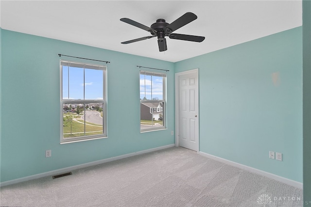 unfurnished room featuring carpet, ceiling fan, and plenty of natural light