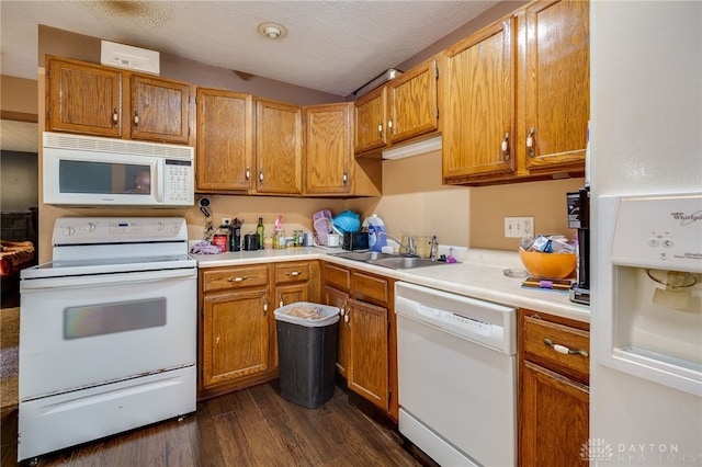 kitchen with sink, white appliances, dark hardwood / wood-style floors, and a textured ceiling