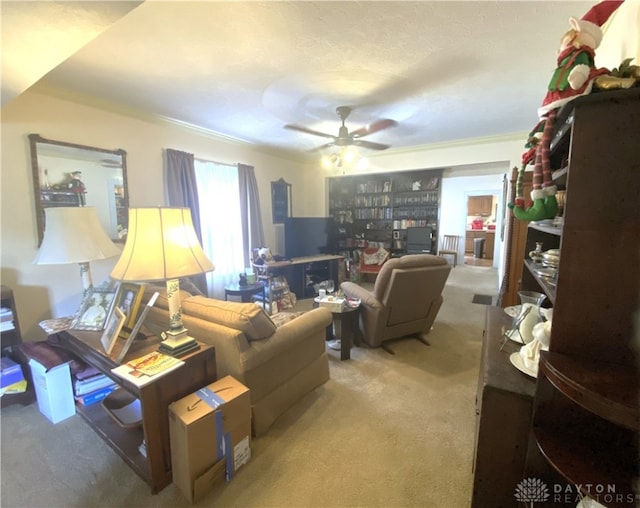 living room featuring carpet floors, ceiling fan, and ornamental molding