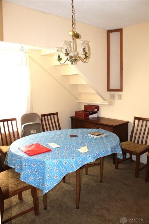 dining area with carpet and a notable chandelier