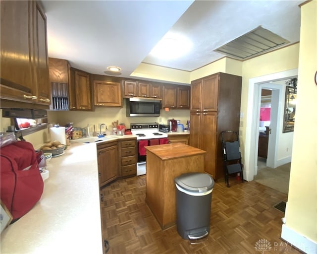 kitchen featuring electric range, sink, butcher block counters, and dark parquet floors