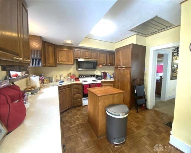 kitchen with wood counters, white electric range, dark parquet flooring, and a center island