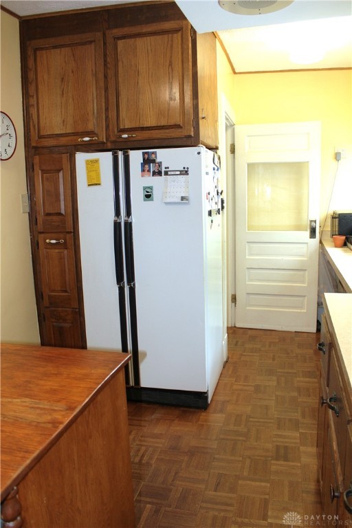 kitchen with dark parquet flooring and white fridge