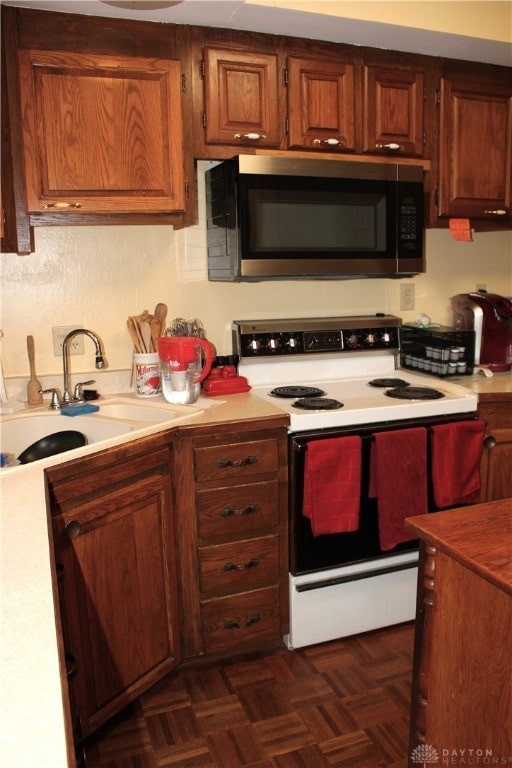 kitchen featuring electric range, dark parquet flooring, and sink