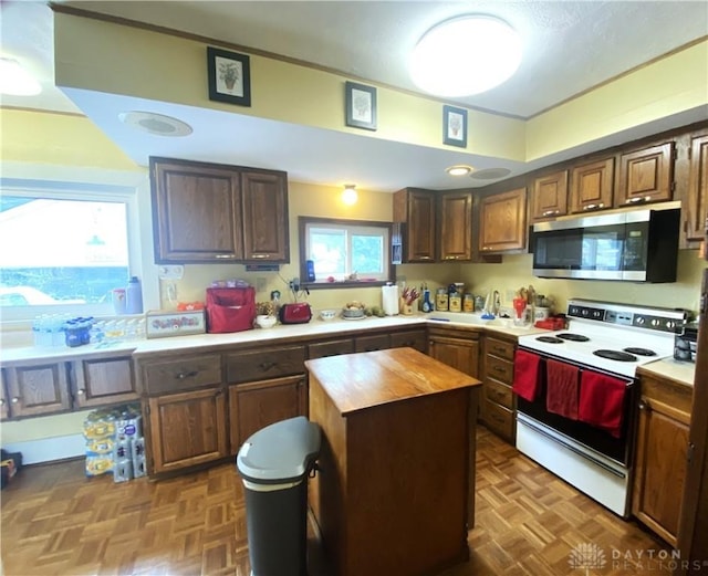 kitchen with wood counters, dark parquet flooring, a center island, and white range with electric cooktop