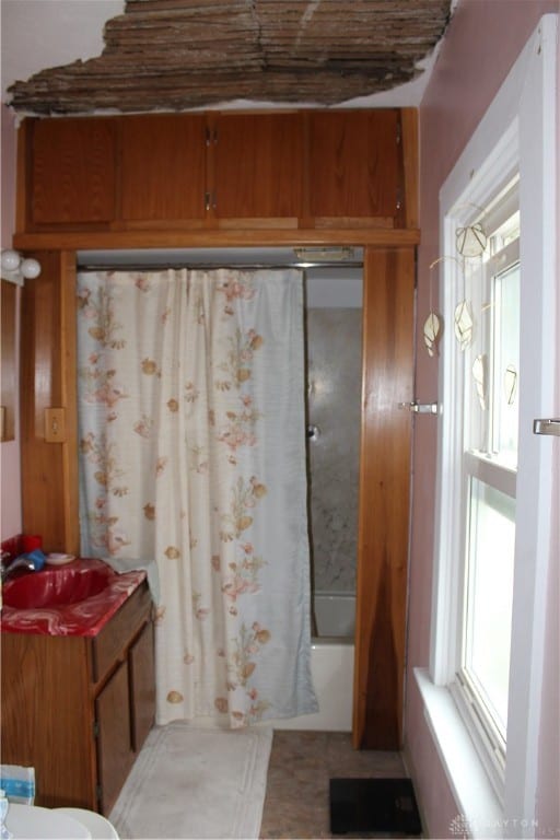 bathroom featuring a healthy amount of sunlight and shower / tub combo with curtain