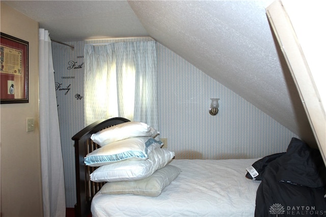 bedroom with a textured ceiling and vaulted ceiling