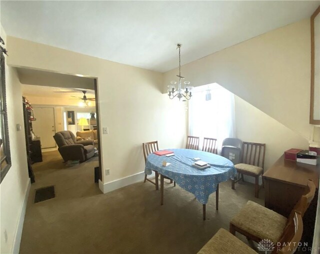 dining area featuring carpet flooring and ceiling fan with notable chandelier