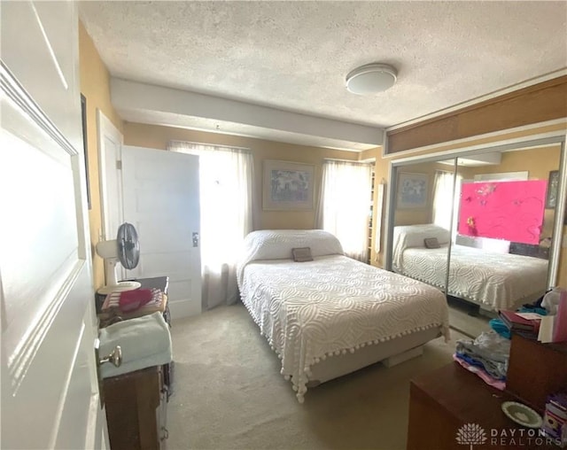 carpeted bedroom featuring a textured ceiling