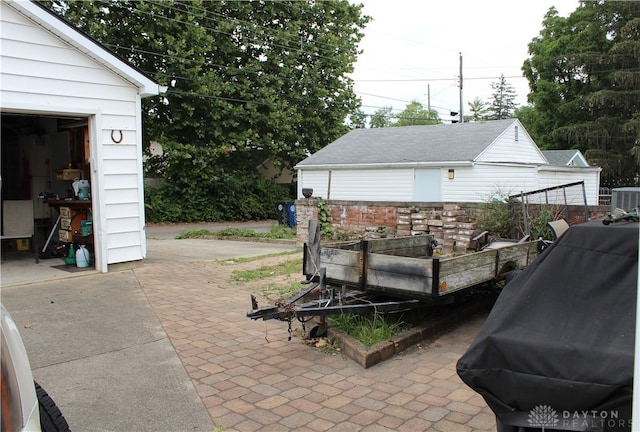 view of patio / terrace featuring cooling unit, an outdoor structure, and a garage