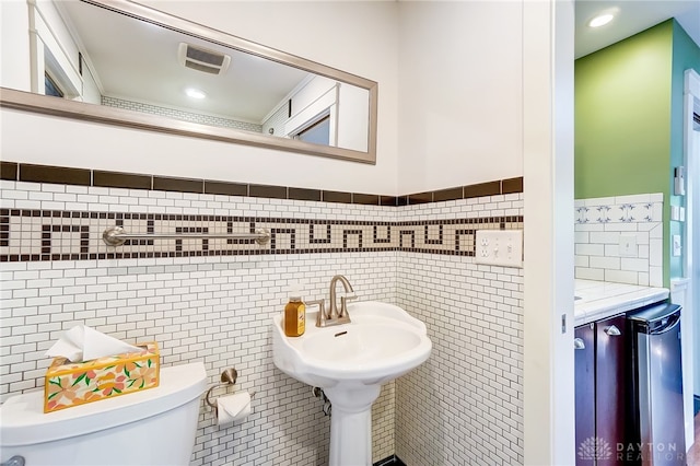 bathroom with tile walls and toilet