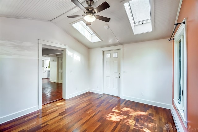 empty room with dark hardwood / wood-style flooring, ceiling fan, and vaulted ceiling with skylight