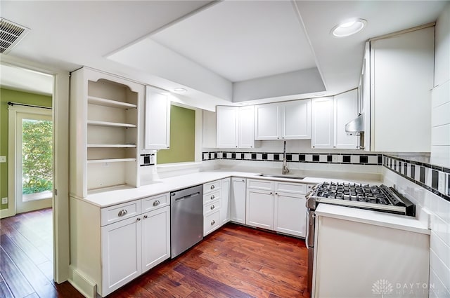 kitchen with appliances with stainless steel finishes, white cabinetry, dark wood-type flooring, and sink