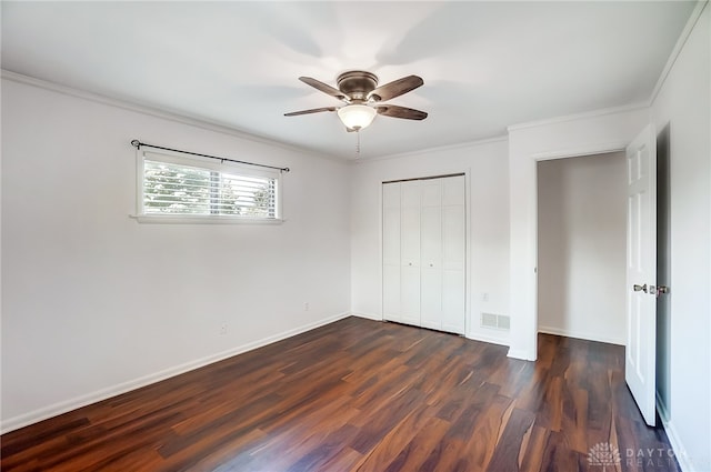 unfurnished bedroom featuring ceiling fan, crown molding, dark wood-type flooring, and a closet