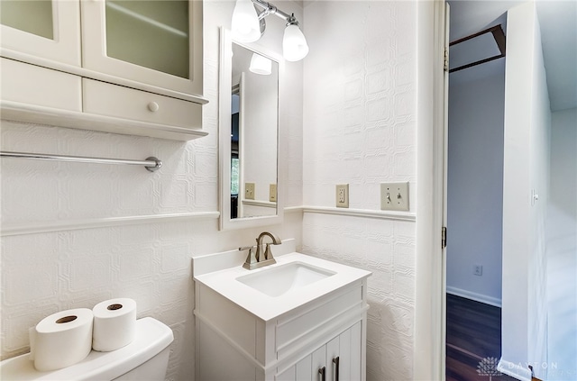 bathroom with hardwood / wood-style floors, vanity, and toilet