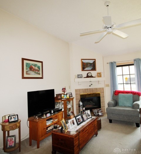 carpeted living room with a tiled fireplace and ceiling fan