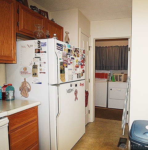 kitchen with tile patterned floors, white fridge, and washer / clothes dryer