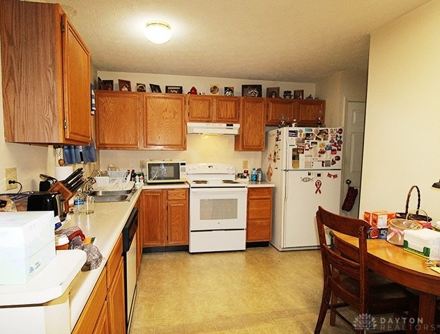 kitchen featuring sink, white appliances, and light tile patterned floors