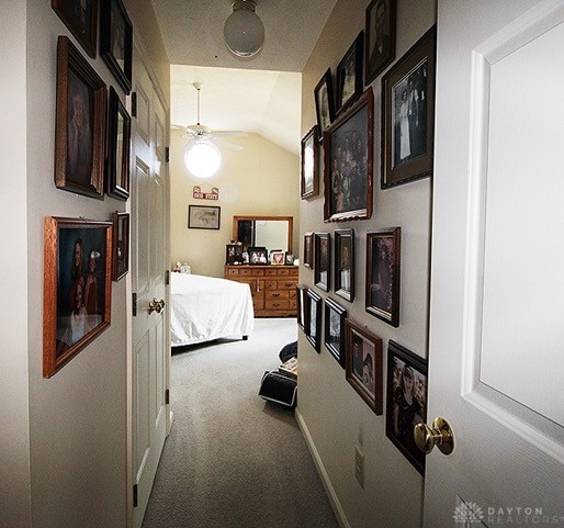 hall featuring carpet flooring and lofted ceiling