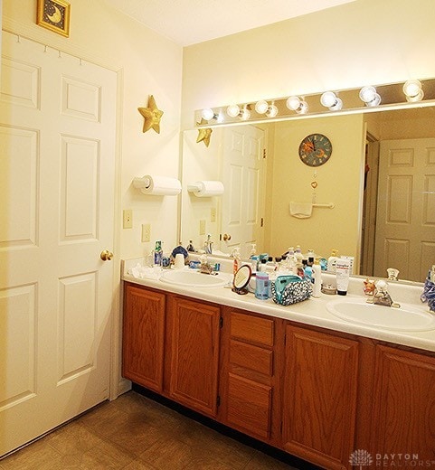 bathroom with tile patterned flooring and dual bowl vanity