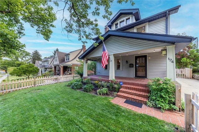 view of front of home with covered porch and a front lawn