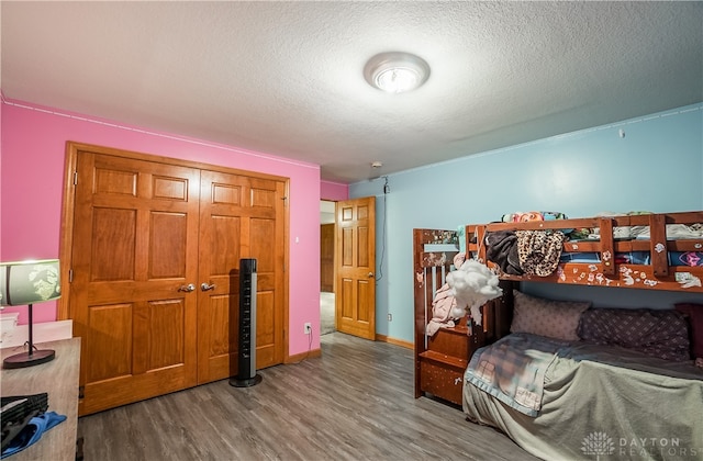 bedroom with a textured ceiling, a closet, and hardwood / wood-style flooring