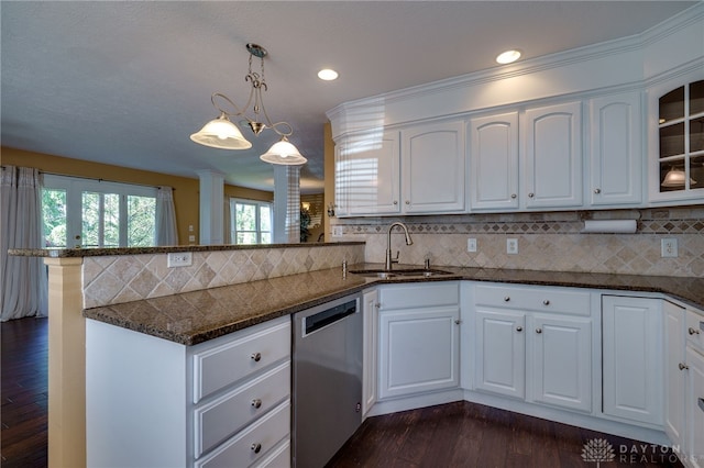 kitchen with pendant lighting, sink, white cabinetry, stainless steel dishwasher, and kitchen peninsula