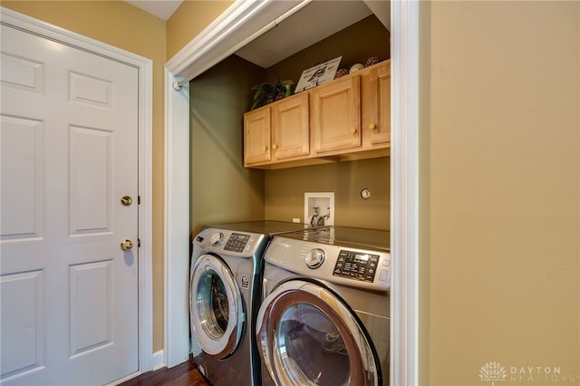 laundry area featuring separate washer and dryer, dark hardwood / wood-style floors, and cabinets