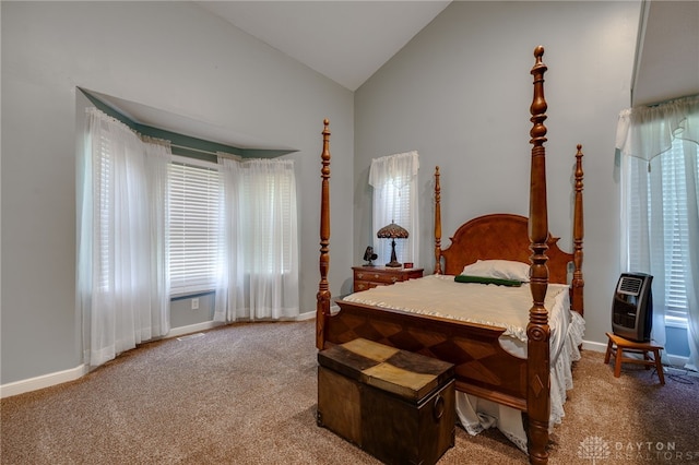 carpeted bedroom with heating unit and high vaulted ceiling