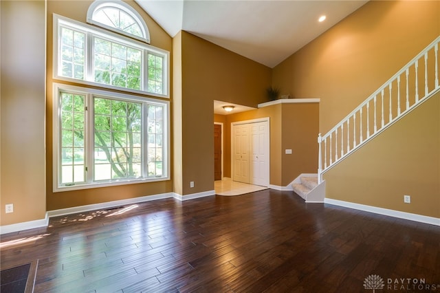 foyer with dark hardwood / wood-style flooring and high vaulted ceiling