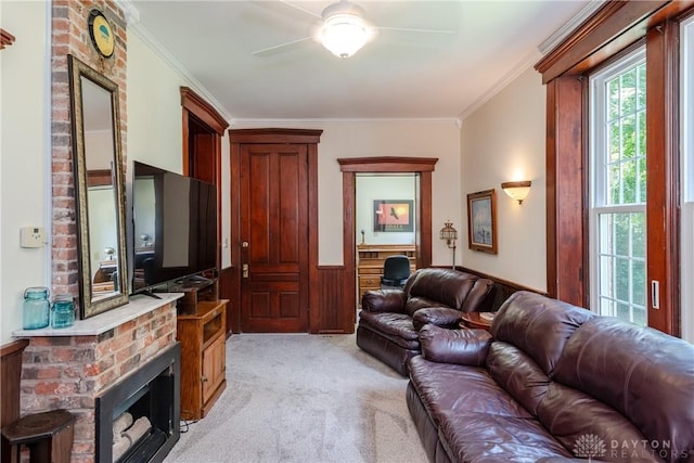 carpeted living room with ceiling fan, a brick fireplace, wooden walls, and ornamental molding