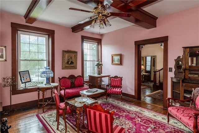 living area featuring ceiling fan, beamed ceiling, and hardwood / wood-style floors