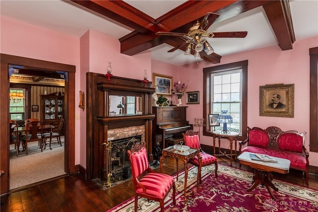 living area with ceiling fan, dark hardwood / wood-style flooring, and a fireplace