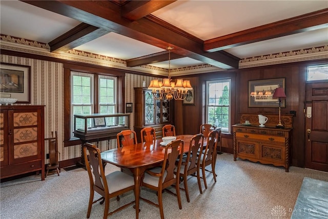 carpeted dining space featuring beam ceiling, coffered ceiling, a chandelier, and ornamental molding