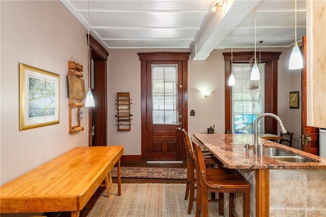 dining area featuring sink and beamed ceiling