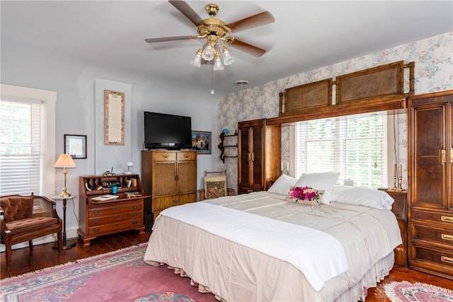 bedroom featuring dark wood-type flooring, ceiling fan, and multiple windows