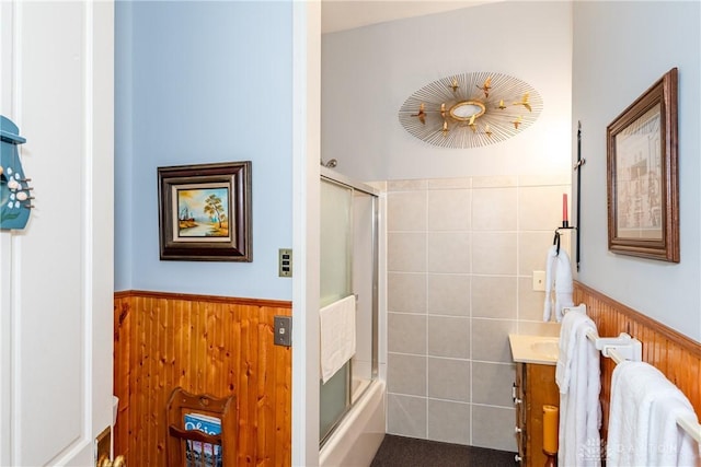 bathroom featuring combined bath / shower with glass door and vanity